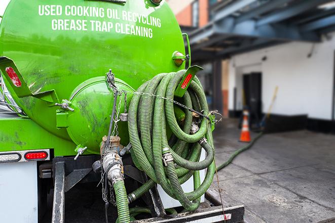 a technician pumping a grease trap in a commercial building in Fitchburg, MA